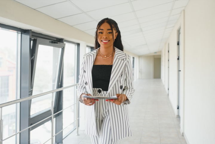 Portrait of African American businesswoman learning tips for first-time real estate investors standing inside office building